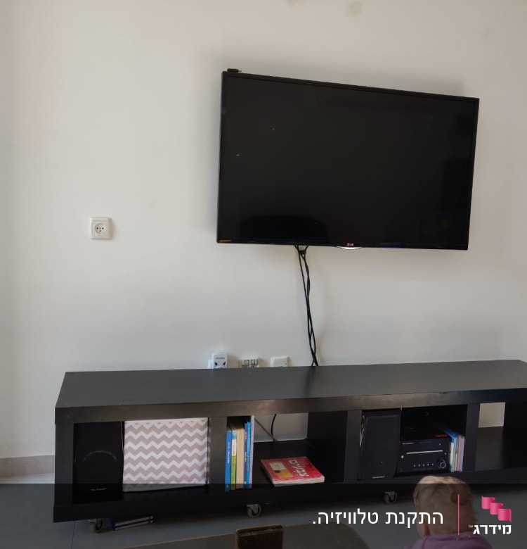 טלוויזיה תלויה על הקיר עם כבלים חשופים